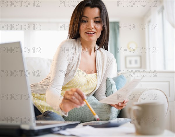 Woman doing paperwork at home. Photo : Jamie Grill