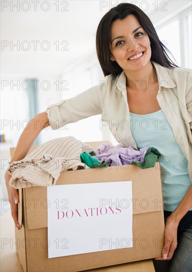 Woman preparing clothes for charity. Photo : Jamie Grill