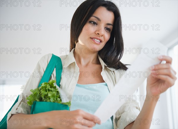 Woman reading receipt. Photo: Jamie Grill