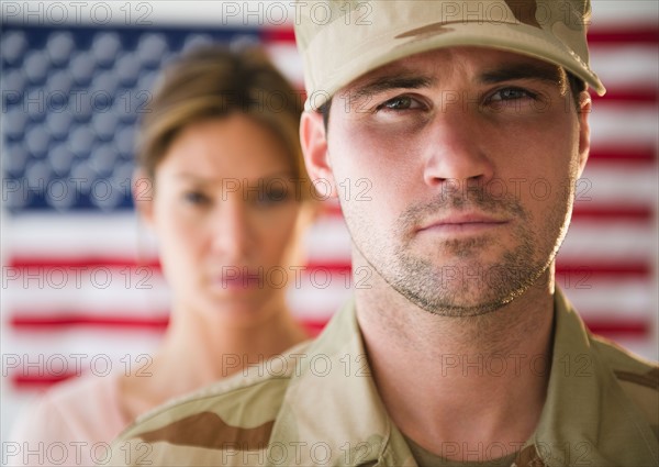 Close up ofsoldier and his girlfriend with american flag in background. Photo : Jamie Grill