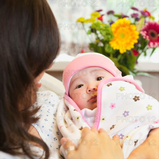 Mother holding baby daughter (2-5 months).