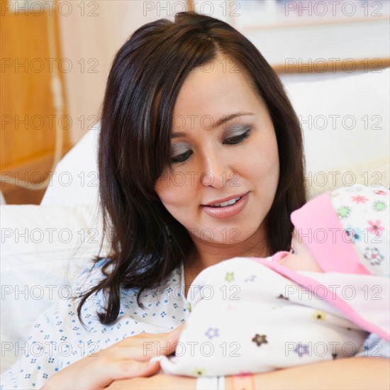 Mother holding baby daughter (2-5 months).