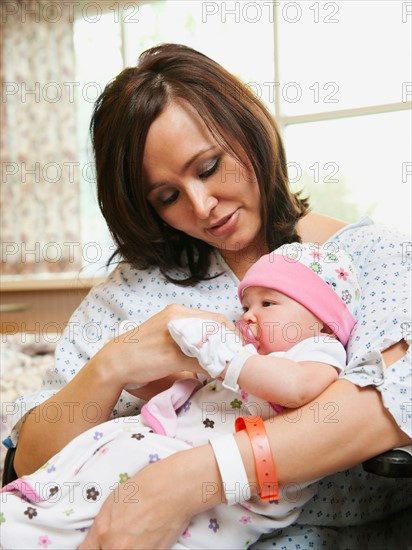 Mother holding baby daughter (2-5 months).