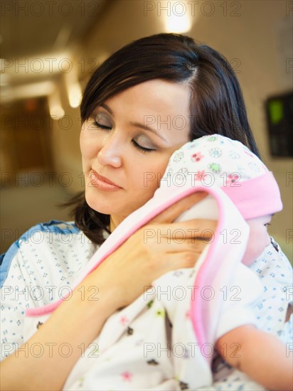 Mother holding baby daughter (2-5 months).