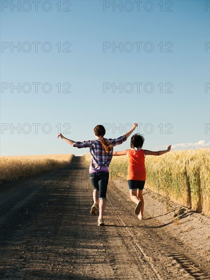 Girls (12-13, 10-11) running along dirt road. Photo: Erik Isakson