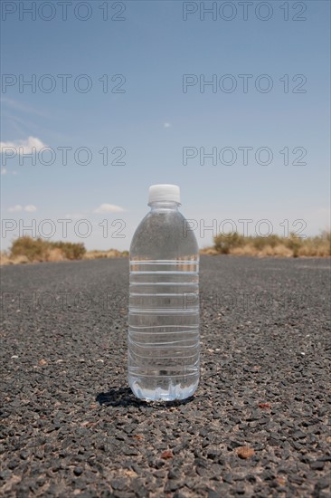 Water bottle sitting in middle of desert road. Photo : Winslow Productions