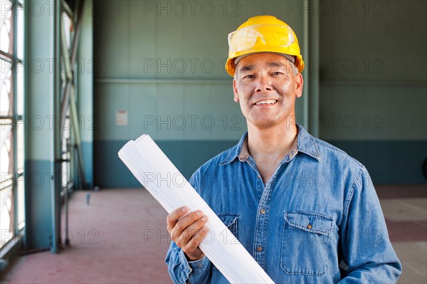 Portrait of architect holding blueprint. Photo: db2stock