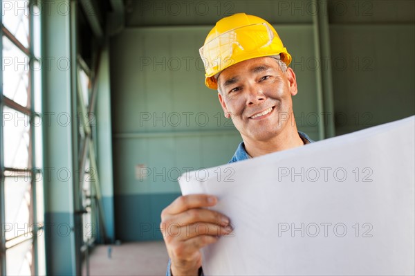 Portrait of architect holding blueprint. Photo : db2stock