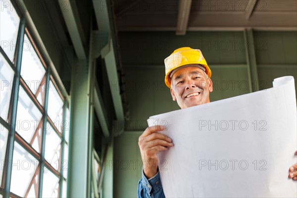 Portrait of architect holding blueprint. Photo : db2stock