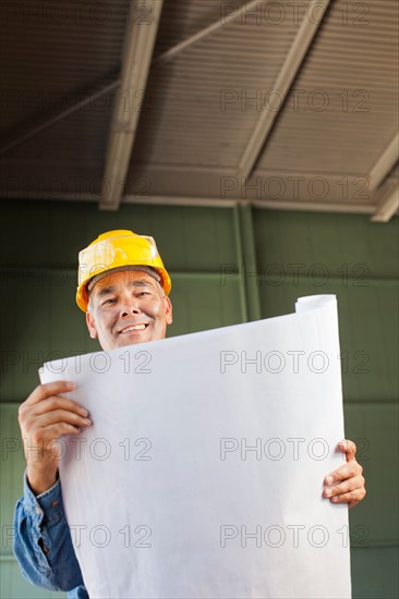 Portrait of architect holding blueprint. Photo : db2stock