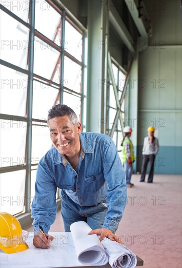 Portrait of architect drawing blueprint. Photo : db2stock