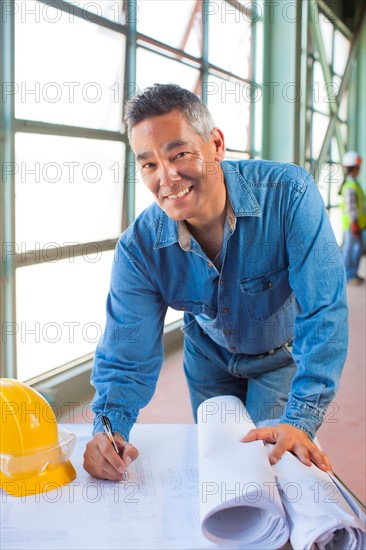 Portrait of architect drawing blueprint. Photo: db2stock