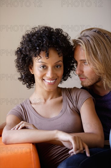 Portrait of young couple sitting in armchair. Photo : Rob Lewine