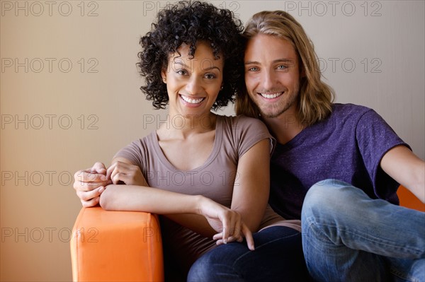 Portrait of young couple sitting in armchair. Photo: Rob Lewine