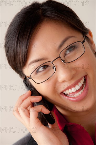 Studio portrait of businesswoman talking on cell phone. Photo : Rob Lewine