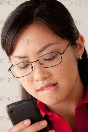 Studio portrait of businesswoman text-messaging. Photo : Rob Lewine