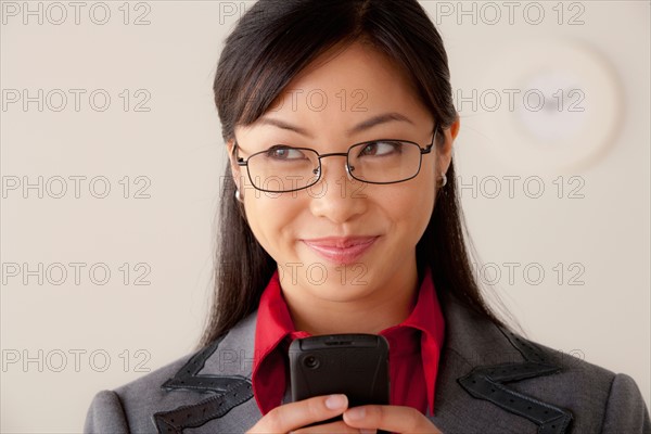 Studio portrait of businesswoman text-messaging. Photo: Rob Lewine