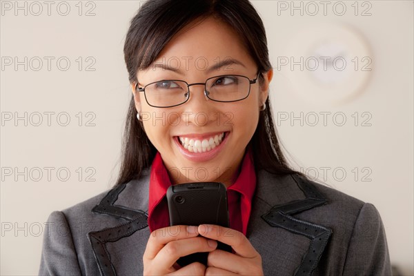 Studio portrait of businesswoman text-messaging. Photo: Rob Lewine