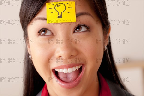 Studio portrait of businesswoman with adhesive note on forehead. Photo : Rob Lewine