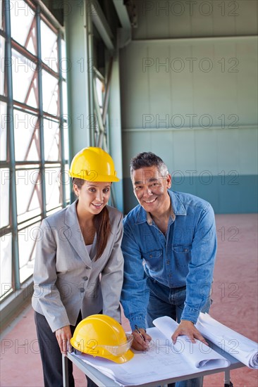 Portrait of architects drawing blueprint. Photo : db2stock