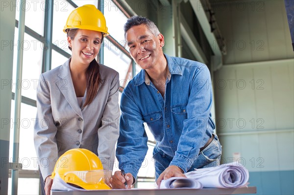 Portrait of architects drawing blueprint. Photo : db2stock