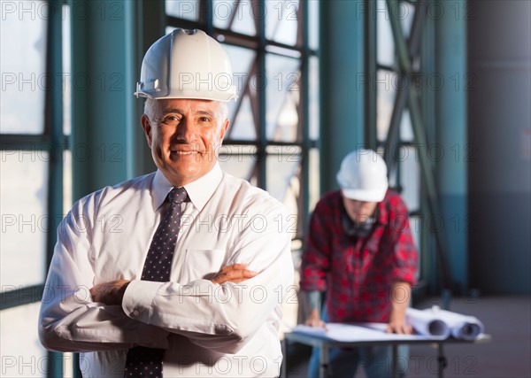 Portrait of man wearing tie and hardhat. Photo: db2stock