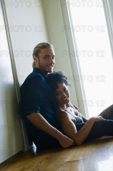 Portrait of young couple sitting on floor. Photo : Rob Lewine