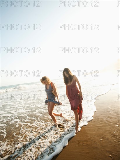 Attractive young woman walking on sandy beach.