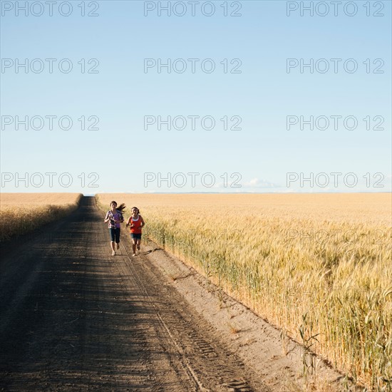 Girls (12-13, 10-11) running along dirt road. Photo: Erik Isakson