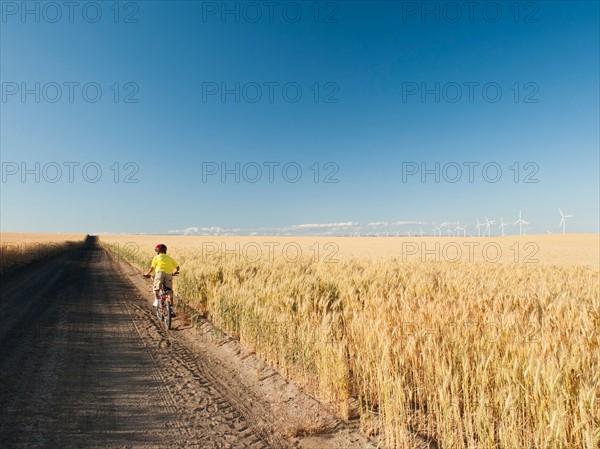 Boy (8-9) cycling along dirt road. Photo: Erik Isakson