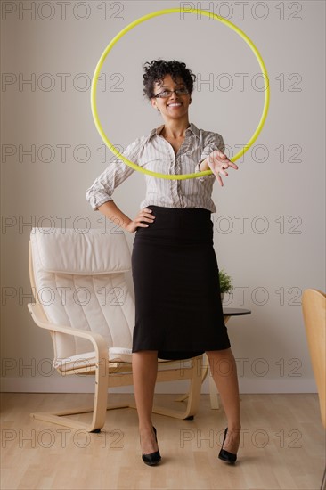 Young businesswoman using hoola hoop. Photo: Rob Lewine