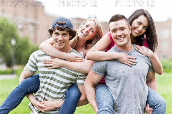 Portrait of two couples piggybacking on campus. Photo : Take A Pix Media