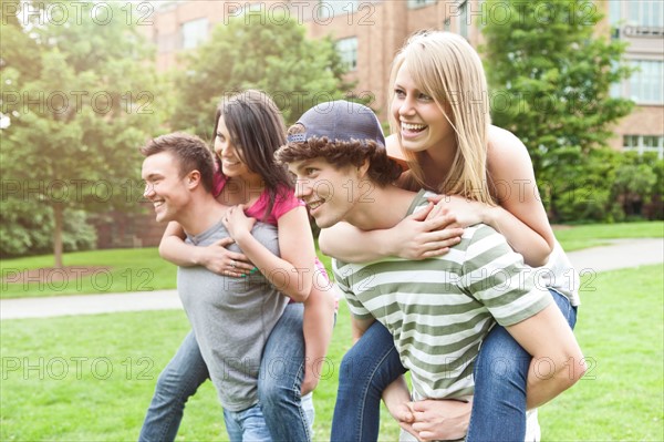 Two couples piggybacking on campus. Photo : Take A Pix Media