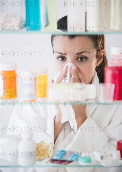 Woman sneezing and using tissue. Photo : Jamie Grill