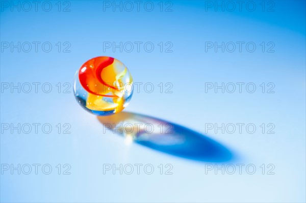 Studio shot of marble ball on blue background.