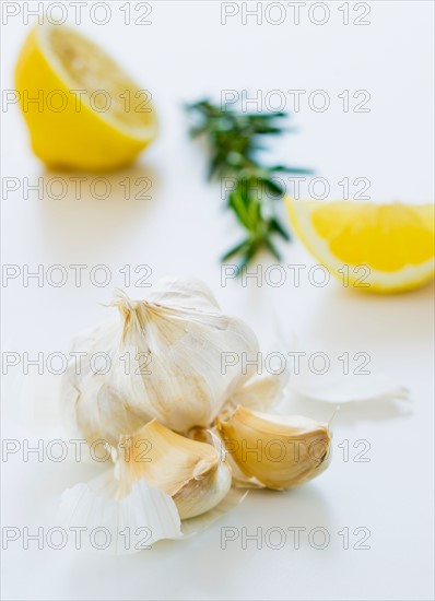 Studio shot of fresh garlic lemon and rosemary.