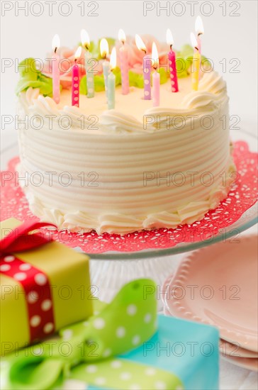 Studio shot of colorful birthday cake and birthday gifts.