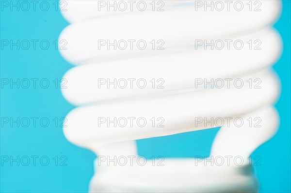 Studio shot of energy efficient lightbulb on blue background.