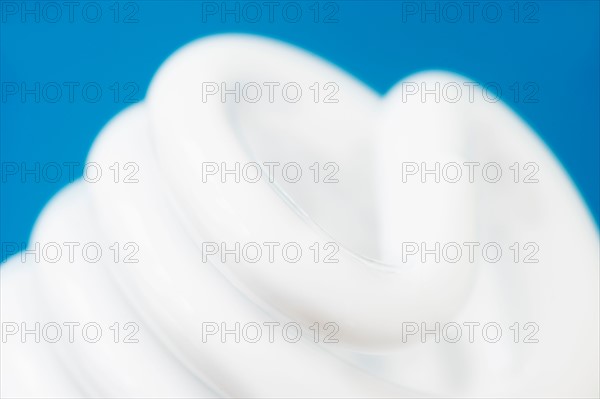 Studio shot of energy efficient lightbulb on blue background.