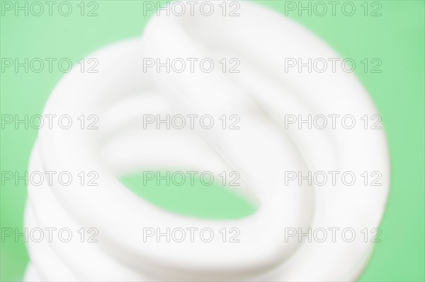 Studio shot of energy efficient lightbulb on green background.