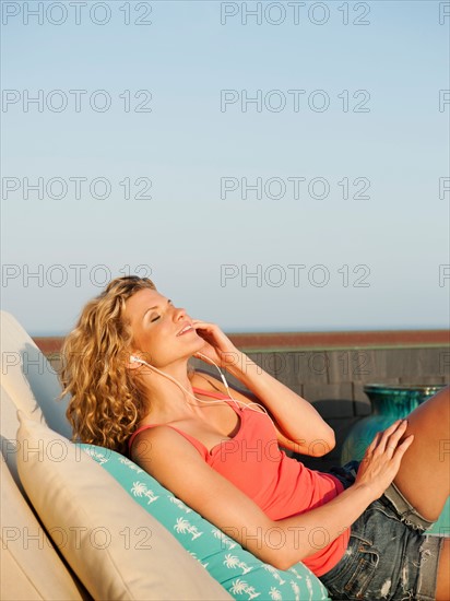 Young attractive listening to music on terrace. Photo: Erik Isakson