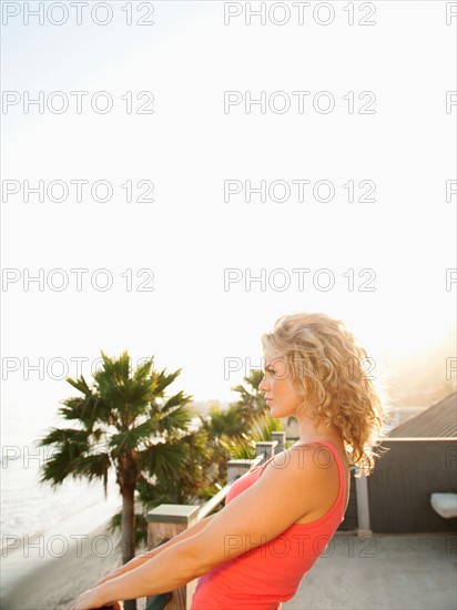 Young attractive woman contemplating seascape from terrace.