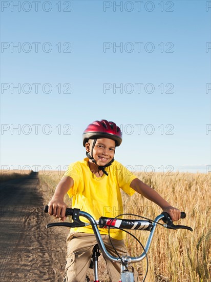 Boy (8-9) cycling along dirt road. Photo: Erik Isakson