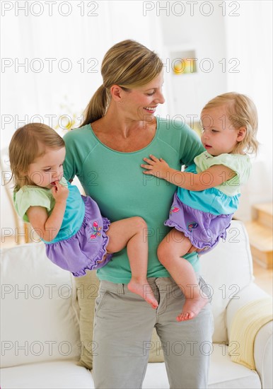Mother with daughters (2-3) in living room.