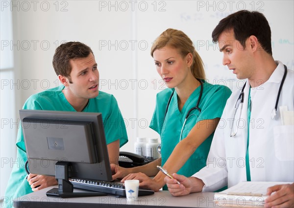 Team of doctors looking at computer.