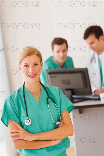 Portrait of female doctor in front of nurse's station.