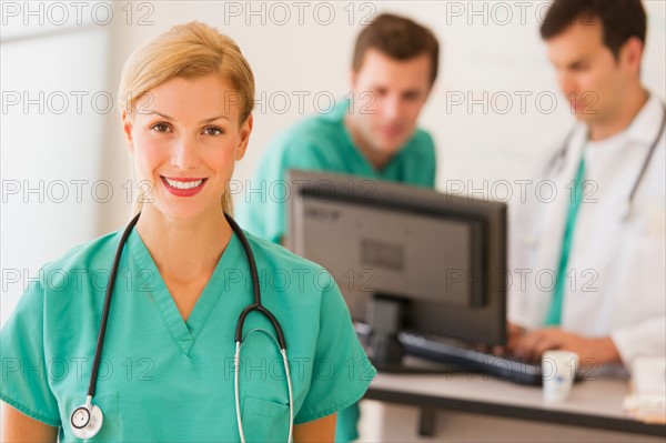 Portrait of female doctor in front of nurse's station.