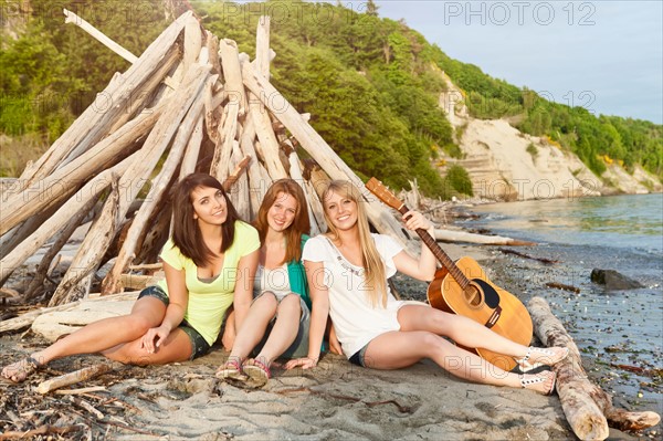 Portrait of three young women hanging out on beach. Photo : Take A Pix Media