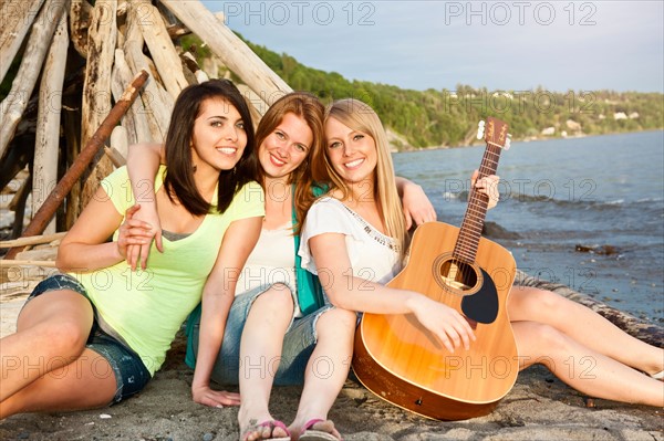 Portrait of three young women hanging out on beach. Photo : Take A Pix Media