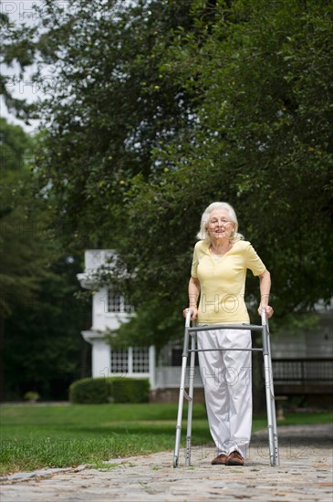 Senior woman walking with walker.